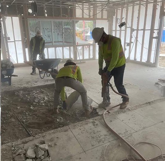 Close-up of DSI worker using claw hammer for selective stud and framing removal during interior demo